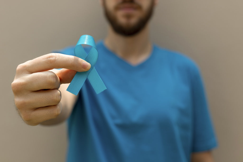 Prostatakrebs: Mann hält die blaue Schleife zu Erinnerung an die Vorsorgeuntersuchung hoch