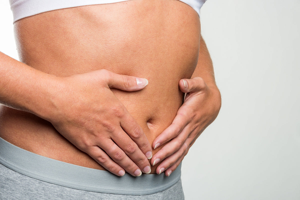 Frau hält sich Bauch - Darmkrebs vorbeugen