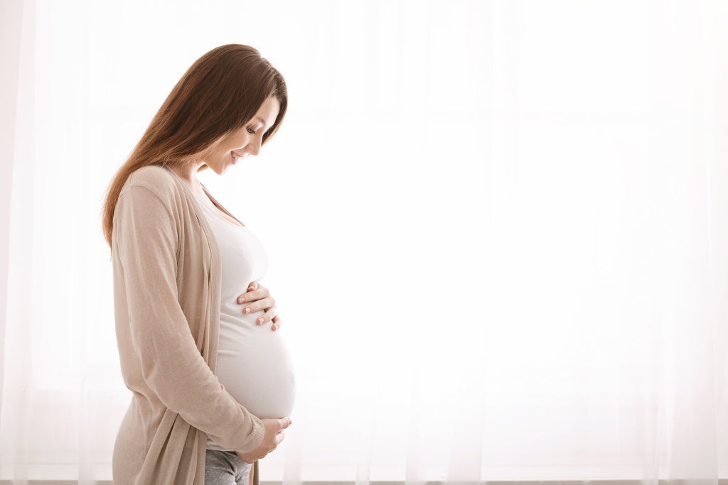 Eisenmangel in der Schwangerschaft: Frau hält schwangeren Bauch 