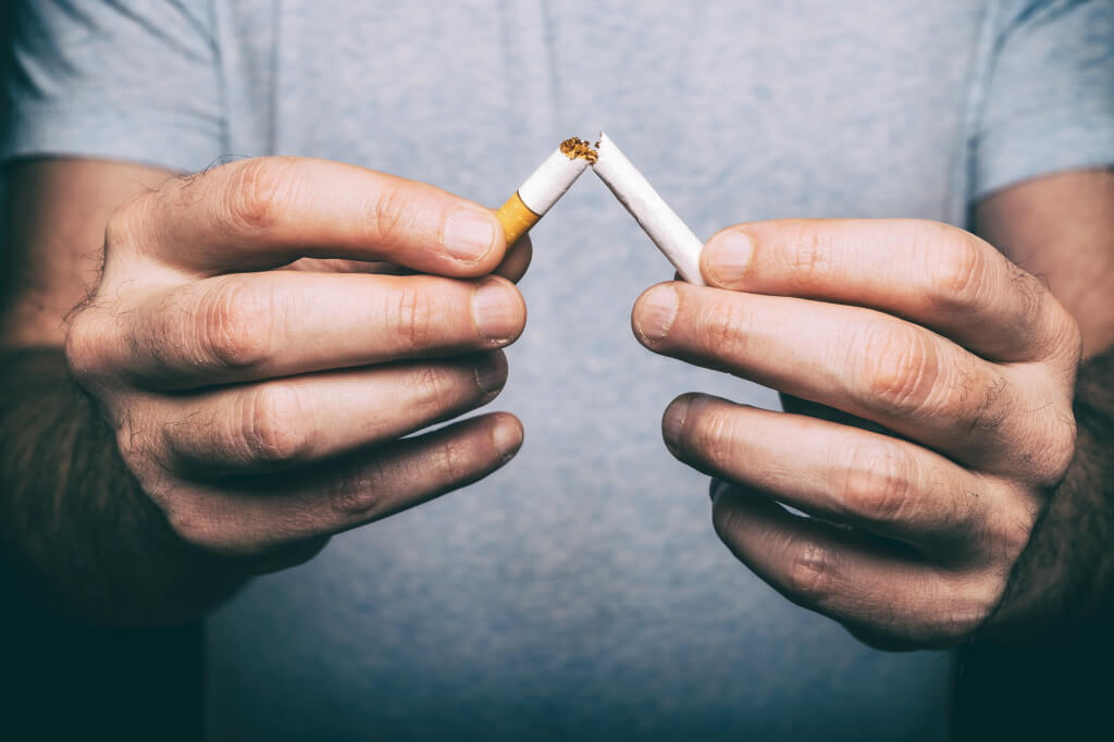 Mit dem rauchen aufhören: Mann zerbricht Zigarette