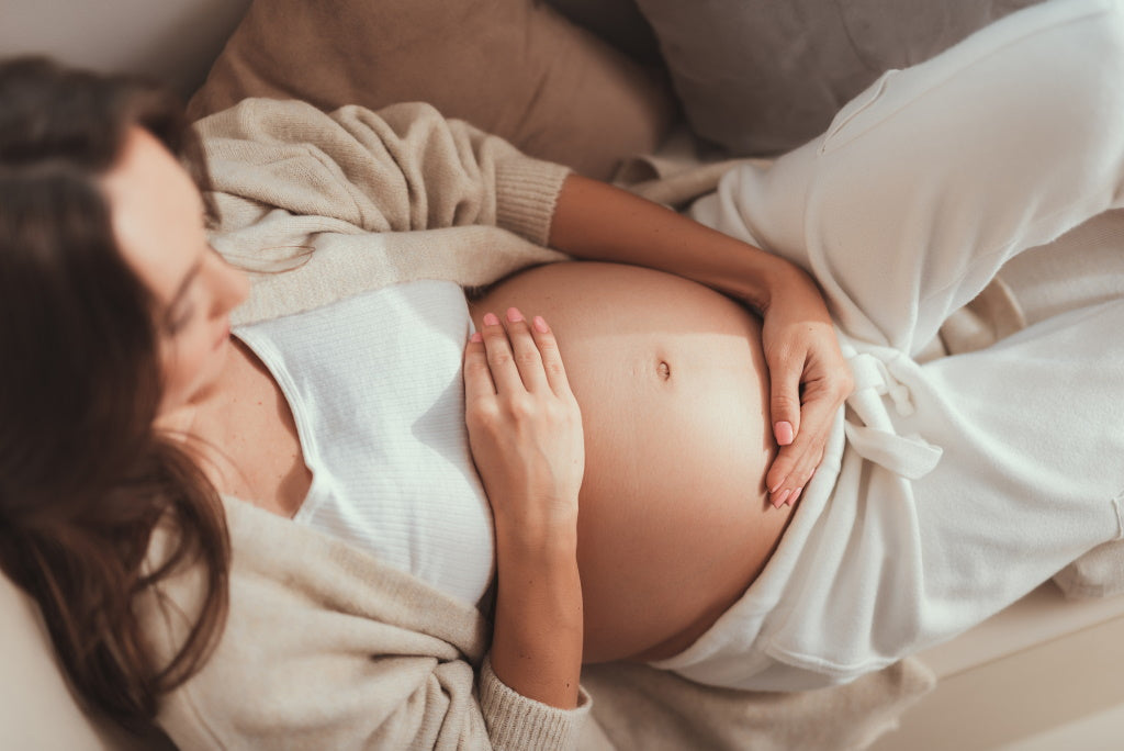 Frau hält ihren schwangeren Bauch
