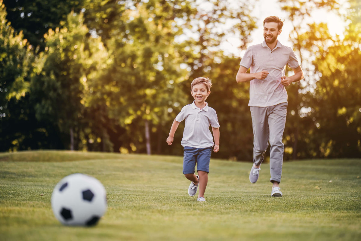 Richtig abnehmen - Kind spielt Fußball mit Vater