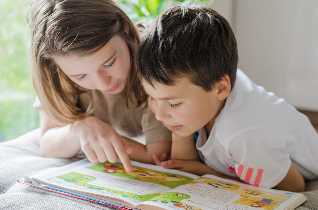 Mädchen und Junge lesen in einem Buch
